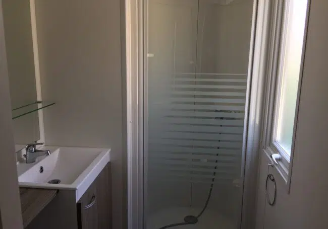 La salle de bain du mobile home bermudes Trio est spacieuse et elle est équipée d'une grande douche