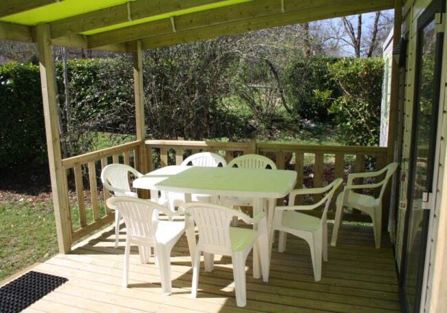 La grande terrasse est couverte. Elle est équipée d'une table avec ses chaises, d'un bain de soleil et d'un fauteuil