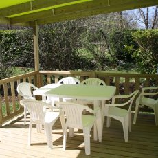 La grande terrasse est couverte. Elle est équipée d'une table avec ses chaises, d'un bain de soleil et d'un fauteuil